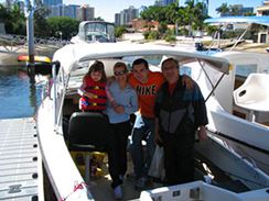 Family of 4 in their half cabin hire boat on the Gold Coast